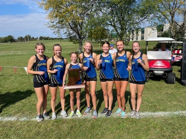girls cross country team of 7 athletes hold trophy 