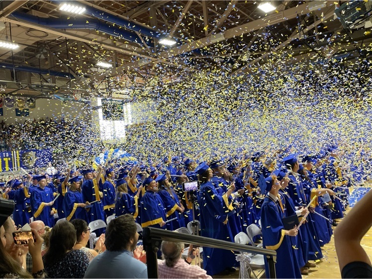 graduating class throwing blue and gold confetti
